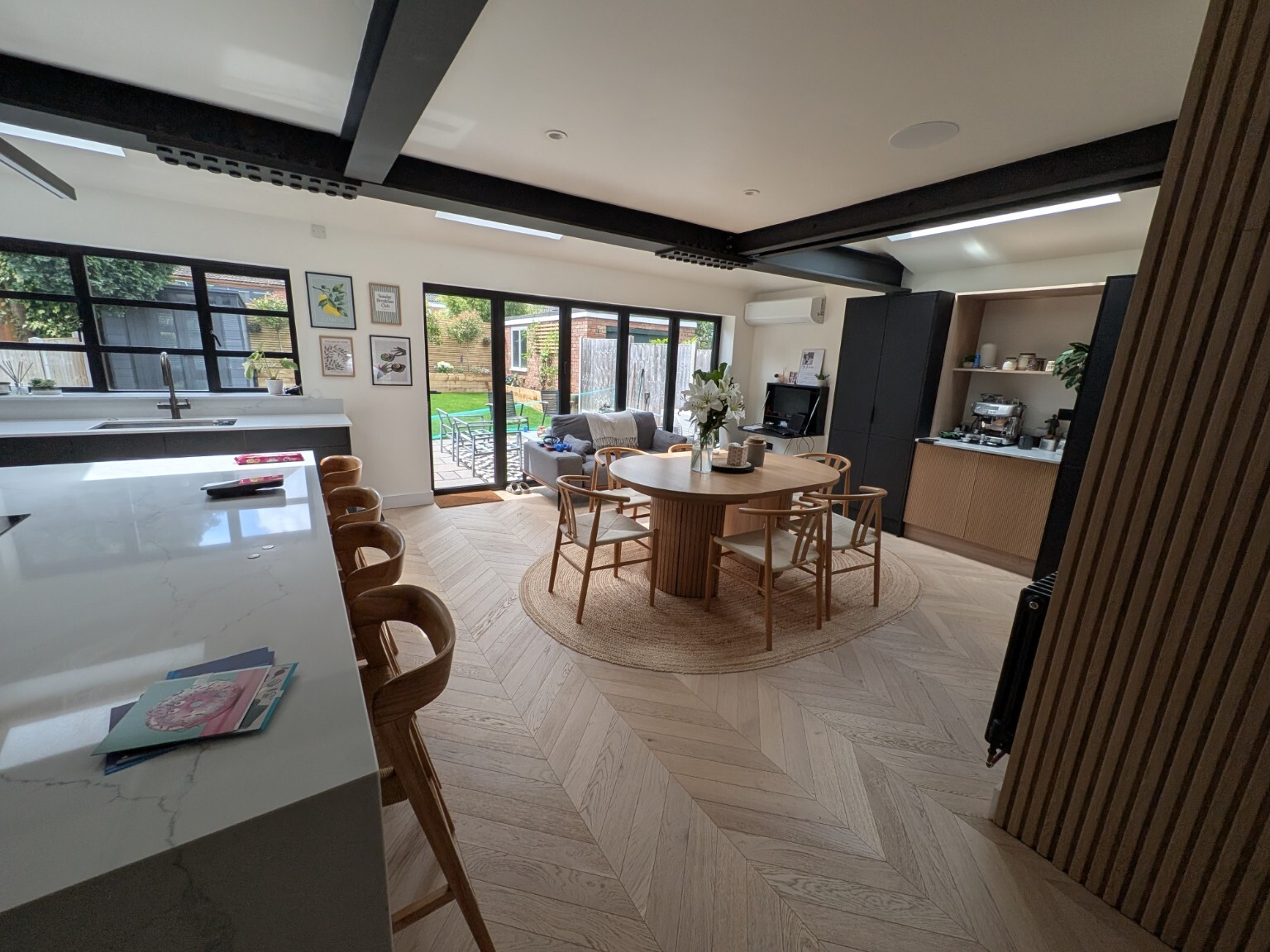 Completed open-plan kitchen and dining renovation with exposed steelwork and wide garden glazing