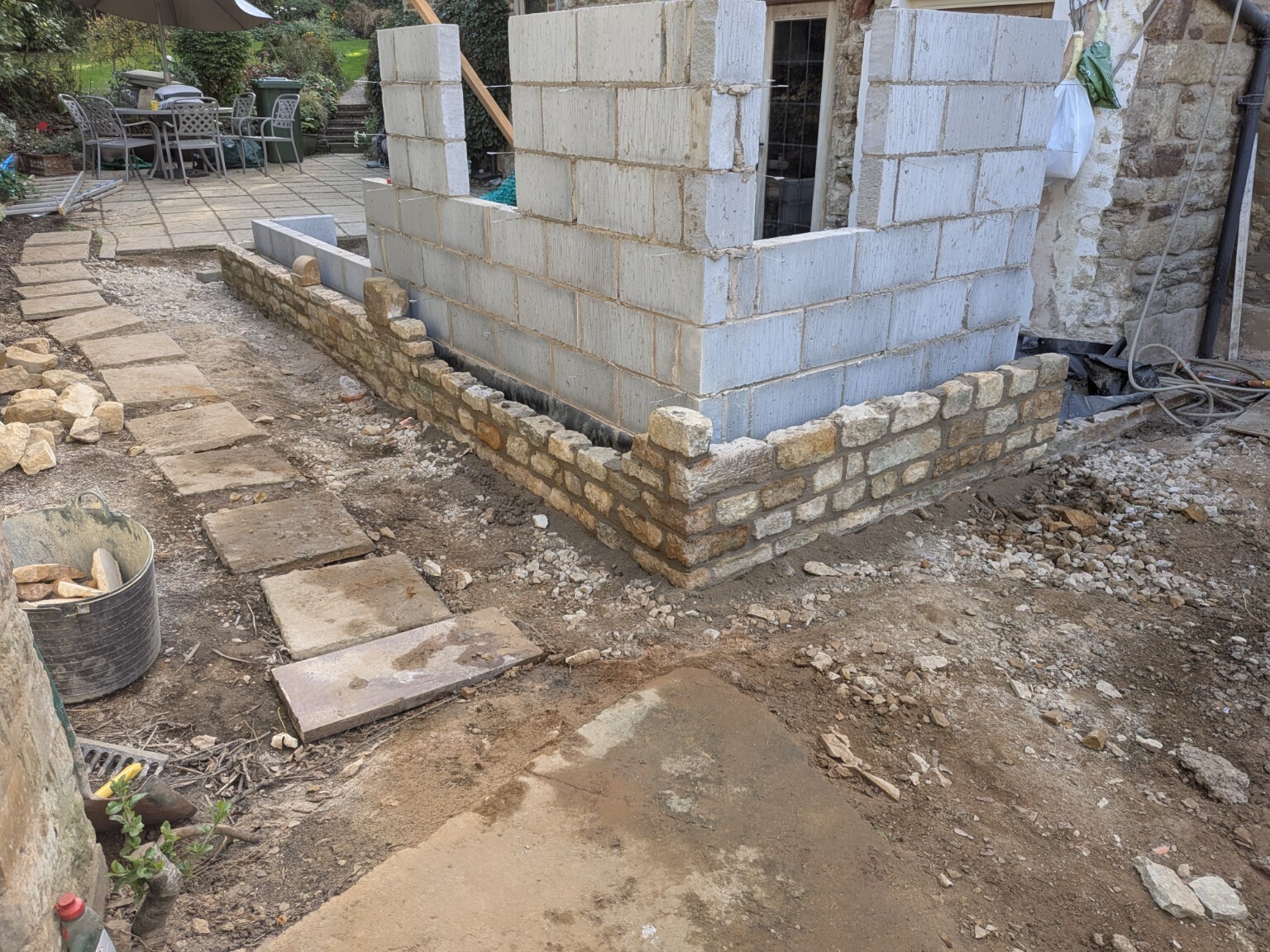 Natural stone outer wall being built around the extension