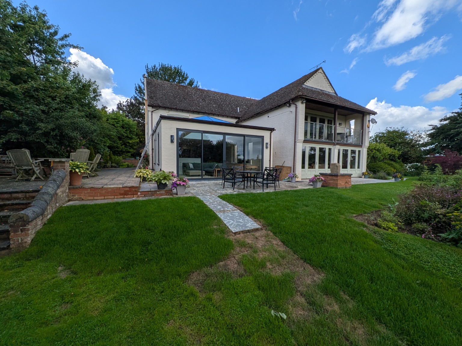 Completed white-painted single-storey house extension with wide glazing and a roof lantern